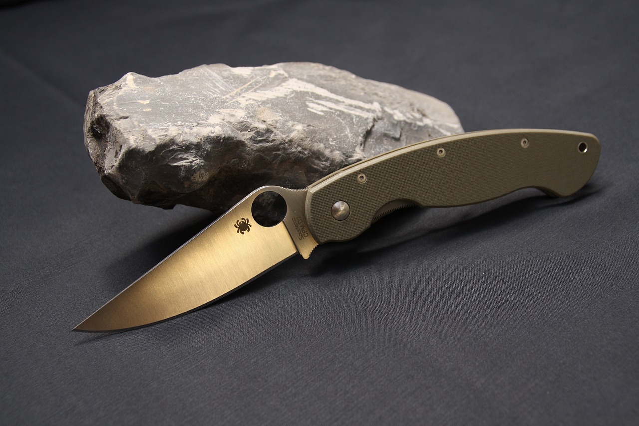 Spyderco folding knife sitting on rock.