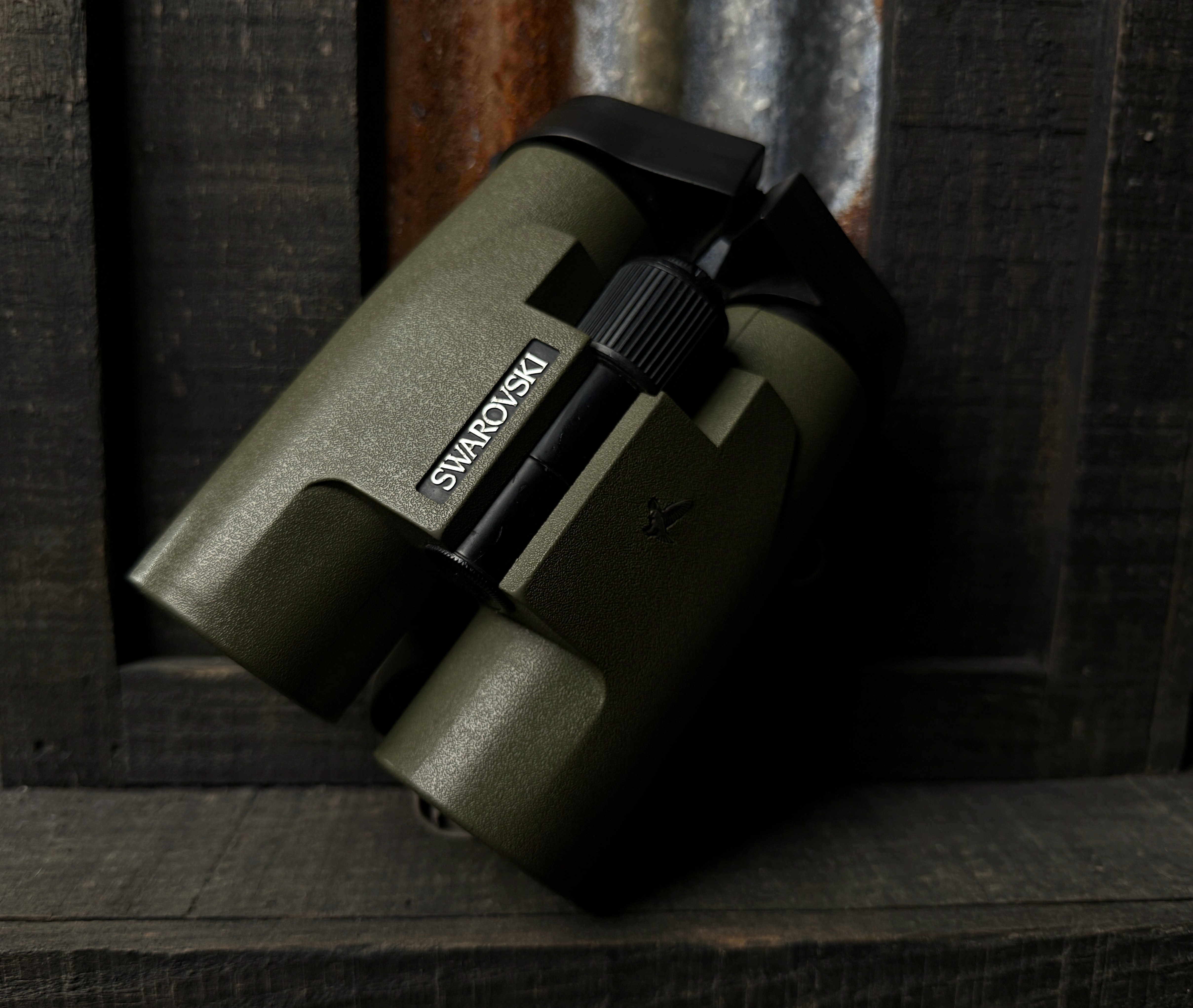 Swarovski binoculars for hunting sitting on rustic metal post